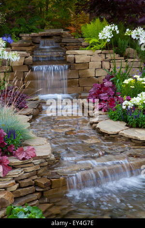 Hard Landscaping in show Garden Tatton Park, Cheshire, Regno Unito 21 luglio, 2015. La riflessione della natura, caratterizzata da una bella serie di lastre di arenaria rovesciate , da cui una cascata leggera si fa strada in una piccola piscina in fondo., RHS mostra di fiori. Foto Stock