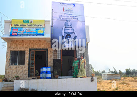 Solapur, India. Xx Febbraio 2014. 20 feb 2014, Solapur, INDIA:.Promodini Jhamble (destra) scorre l'acqua filtrata shop fornite da Eureka Forbes per la fornitura di acqua potabile filtrata per la popolazione rurale di un villaggio vicino Viratnagar Solapur.economicamente i mercati dei paesi poveri nella baraccopoli urbane & villaggi rurali in India stanno diventando sempre più importanti per le grandi società multinazionali come loro obiettivo la domanda di acqua dolce.Circa 96 milioni di persone in India non hanno accesso ad acqua pulita e più di 186000 bambini al di sotto dei cinque anni muoiono di diarrea provocata da acqua non sicuri e poveri san Foto Stock