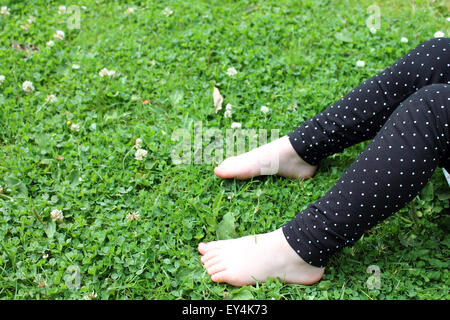 Il Toddler girl che stabilisce nel verde prato, Cardiff, Regno Unito Foto Stock