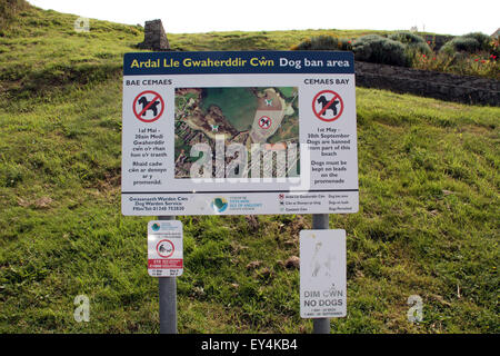 Sign in gallese e inglese spiegando dove le persone possono raggiungere a piedi i cani sulla spiaggia a Cemaes Anglesey North Wales Foto Stock