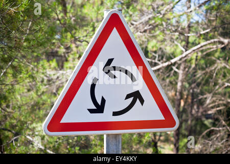 Rotonda triangolo segno di traffico su sfondo natura Foto Stock