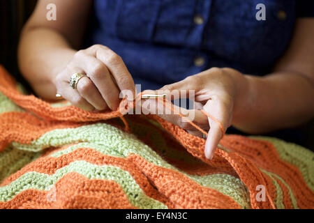 Chiudere l immagine di una donna caucasica a crochet in casa Foto Stock