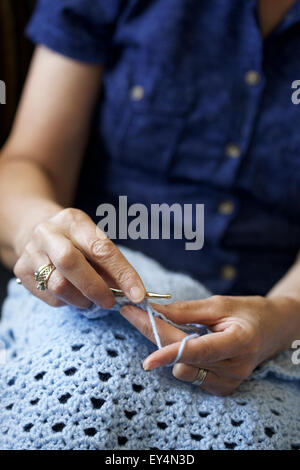 Chiudere l immagine di una donna caucasica a crochet in casa Foto Stock