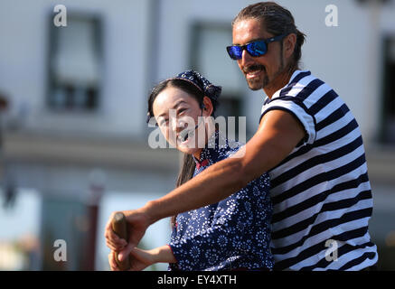 Venezia, Italia. 21 Luglio, 2015. Un gondoliere insegna Wu Juan (L), una chiatta-donna da Zhouzhuang per gestire una gondola (un tradizionale fondo piatto veneziano barca a remi) a Venezia, Italia, il 21 luglio 2015. Durante l'Expo Milano 2015, della Cina di Zhouzhuang tiene un seminario a Milano e un evento chiamato "un racconto di due città d' Arte a Venezia per introdurre la cultura cinese di "Città d'acqua". © Jin Yu/Xinhua/Alamy Live News Foto Stock