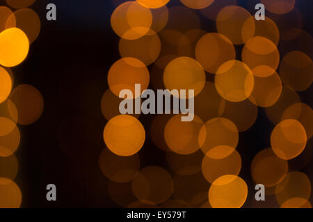 LED scintillanti luci di colore arancione con un buio torna sfondo usando un defocalizzata bokeh di fondo tecnica di stile Foto Stock