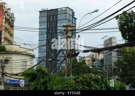 Una ridda di cavi telefonici al di sopra di una strada a Saigon, Vietnam Foto Stock