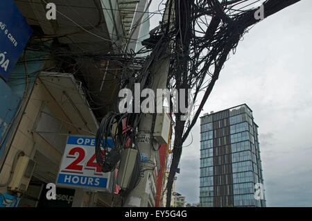 Una ridda di cavi telefonici al di sopra di una strada a Saigon, Vietnam Foto Stock