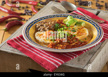 Huevos rancheros. Uova fritte sulle tortillas con pomodoro salsa chili e refried fagioli Foto Stock