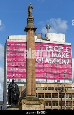 Scott Monument su George Square Glasgow nel centro della città, Scozia, Regno Unito con la gente fare segno Glasgow sullo sfondo Foto Stock