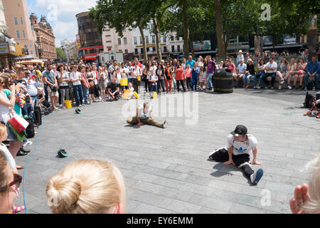 Gli artisti di strada a ballare un pubblico nel quadrato di Leicester, Londra Inghilterra REGNO UNITO Foto Stock