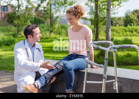 Vista di un medico aiuta una giovane donna durante la rieducazione Foto Stock
