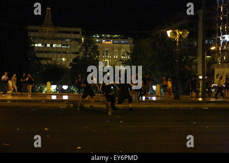 Atene, Grecia. Il 22 luglio 2015. Manifestanti scagliare pietre verso la polizia alla protesta contro la seconda tranche dei greco-misure di austerità in Atene. I Greci hanno protestato fuori del parlamento greco come il 2. quota delle nuove misure di austerità sono state discusse in Parlamento. Le nuove normative includono un diritto e riforma bancaria. La protesta è rimasta per lo più tranquilla con un paio di tafferugli tra la polizia e gli anarchici alla fine. Credito: Michael Debets/Alamy Live News Foto Stock