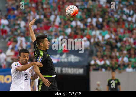 Tempo Extra. 19 Luglio, 2015. Messico avanti Oribe Peralta (19) colpisce una posa come egli reagisce alla voce una palla sulla Costa Rica defender Giancarlo Gonzalez (3) durante i quarti di finale della CONCACAF Gold Cup match tra Messico e Costa Rica a Met Life Stadium, East Rutherford, NJ. Il Messico ha sconfitto il Costa Rica 1-0 nell'ultimo minuto del tempo supplementare. Credito: Kostas Lymperopoulos/CSM/Alamy Live News Foto Stock