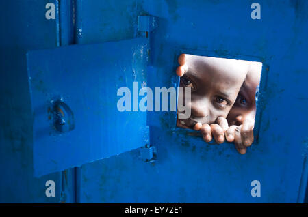 Due giovani ragazzi guarda attraverso la porta di una chiesa in un campo di rifugiati in Pader, Uganda settentrionale, Africa. Foto © Becky Matthews Foto Stock