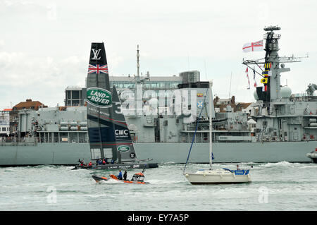 Portsmouth, Regno Unito. 23 Luglio, 2015. Il passato di vela presso la Coppa America World Series di Portsmouth. Sir Ben Ainslie al timone di Land Rover BAR, il Challenger del Regno Unito al fianco di HMS St Albans come lasciano il porto di Portsmouth. Credito: Rob Wilkinson/ Alamy Live News Foto Stock