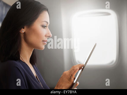 Giovane donna utilizzando tablet sul piano Foto Stock