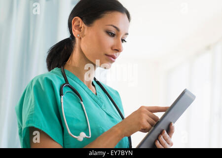 Medico donna utilizzando tavoletta digitale Foto Stock