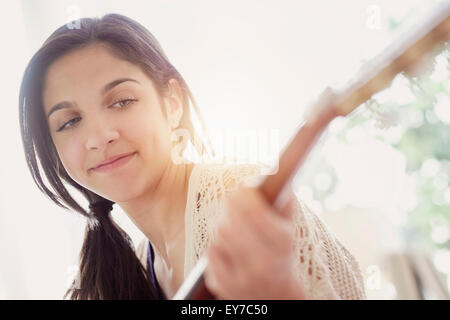 Ragazza adolescente (14-15) a suonare la chitarra Foto Stock