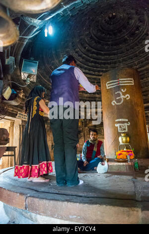 I rituali religiosi essendo eseguita all'interno di un tempio indù di Khajuraho, Madhya Pradesh, India Foto Stock