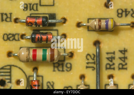 Resistori e diodi a macro-foto-carbonio su circuito stampato a foro passante tradizionale. Resistenza elettrica, immagine dettagliata del primo piano del circuito. Foto Stock