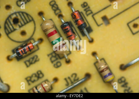 Macrofotografia di resistori e diodi al carbonio su una scheda a circuito stampato (PCB) a foro passante. Concetto di resistenza, resistenza elettrica, primo piano del circuito. Foto Stock
