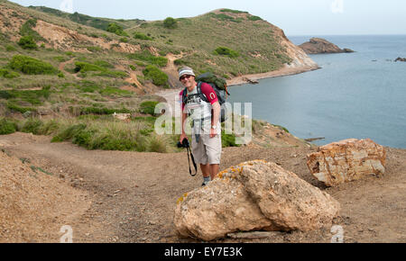 Un escursionista passeggiate lungo uno sperone nord del sentiero costiero di Cami de Cavalls bridal trail sull isola di Minorca spagna Foto Stock