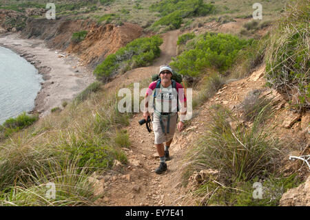 Un escursionista passeggiate lungo uno sperone nord del sentiero costiero di Cami de Cavalls bridal trail sull isola di Minorca spagna Foto Stock