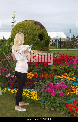 Cheshire, Regno Unito. 23 Luglio, 2015. Xvii RHS annuale Festival dei Fiori  Ashleigh Edwards, 24 anni si ammira il 'Day delle Dalie' visualizzazione in showground arena a Tatton Park, Knutsford nel Cheshire. Regno Unito. Credito: Cernan Elias/Alamy Live News Foto Stock