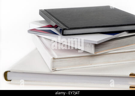 Pila di libri isolati su sfondo bianco Foto Stock