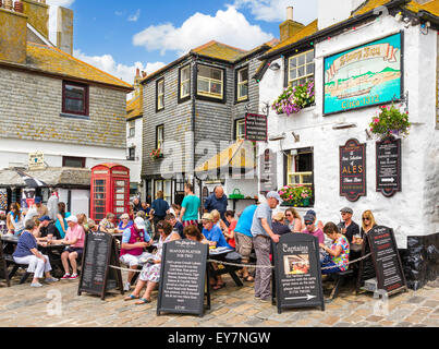 La gente seduta al di fuori del centro storico Sloop in sul lungomare, Wharf Road, St Ives, Cornwall, Regno Unito Foto Stock