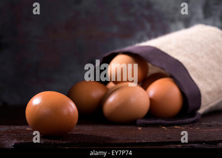 Alcune uova su uno sfondo di legno Foto Stock