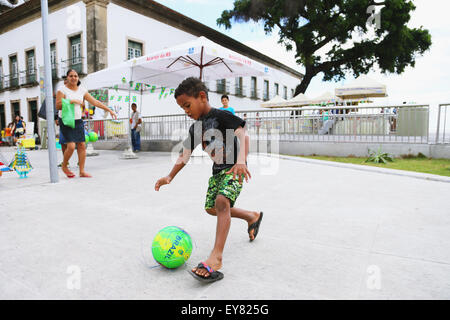 Ragazzi che giocano a calcio per strada, Brasile Foto Stock