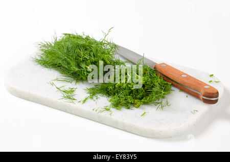 Ciuffi di foglie di aneto fresco sul bordo di taglio Foto Stock