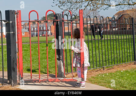 Bambino in piedi dalla porta giochi Foto Stock