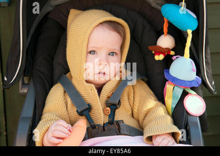 Ritratto di bambina seduto nel suo contenuto della PRAM Foto Stock