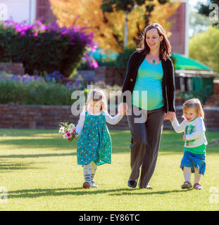 Donna incinta con le sue figlie camminando sul prato del parco, Tintenpalast, Windhoek, in Namibia Foto Stock
