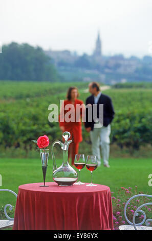 Il vino francese, formaggio e pane con coppia nei vigneti con Saint Emilion campanile al di là Foto Stock