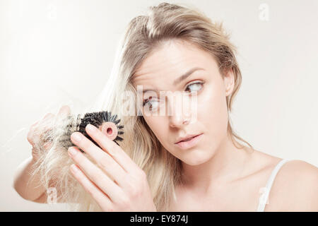 Giovane donna spazzolare i capelli Foto Stock