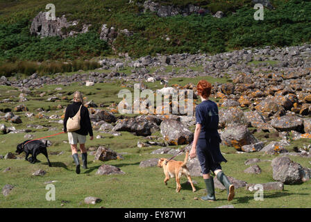 Vista posteriore di madre e figlio a piedi con i loro cani Foto Stock