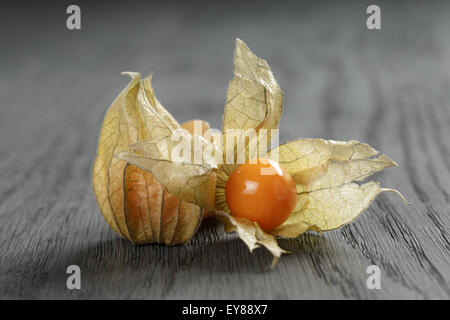 Physalis frutto nella tazza di olive su oak tavolo in legno Foto Stock