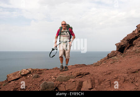 Un rambler camminando sulla cima di una scogliera sul Cami de Cavalls trail sull isola di Minorca spagna Foto Stock