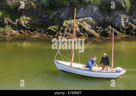 Due uomini che si divertono a navigare in barca al porto di Porthclais vicino a St Davids al Pembrokeshire Coast National Park, Galles UK a maggio Foto Stock