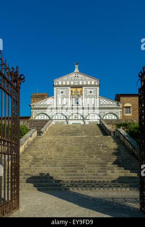 Esterno di San Miniato al Monte shot attraverso un cancello aperto ai piedi delle fasi. Firenze, Italia. Foto Stock