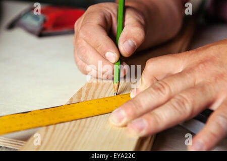 Mani maschio con righello e matita closeup. Professional carpenter al lavoro. Foto Stock