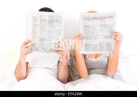 Vista di una coppia in un letto quotidiano di lettura Foto Stock