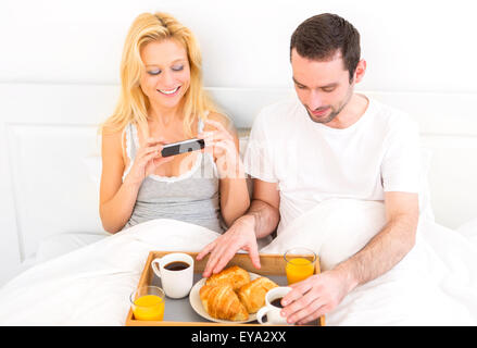 Vista di una giovane donna attraente a scattare foto di prima colazione Foto Stock