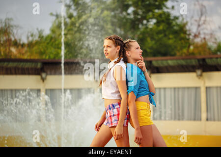 I migliori amici di stand di schiena vicino alla fontana in estate park. Ragazze vestito in pantaloncini corti e una maglietta. Le vacanze estive. Foto Stock