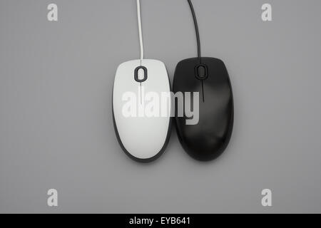 Il bianco e il nero mouse con cavi su sfondo grigio Foto Stock