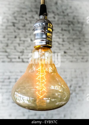 Luce calda lampadina con mattoni della parete rivestita Foto Stock