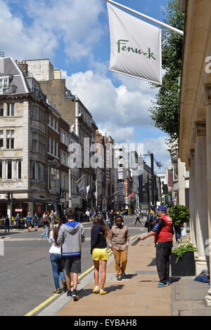 Un grande problema venditore al di fuori dell'entrata di Fenwick su New Bond Street Foto Stock